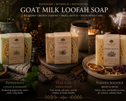 Three bars of goat milk loofah soap by The Root of It Apothecary are displayed in a cozy, rustic holiday setting with candles, pinecones, and tea accessories. The soaps are labeled Peppermint, Yule Log, and Steeped Solstice, with descriptive text overlays at the bottom.