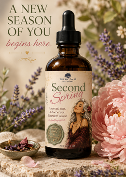 An amber glass dropper bottle labeled 'Second Spring' by The Root of It Apothecary, styled on a stone surface with pink flowers, lavender, and dried botanicals. Text on the left reads 'A NEW SEASON OF YOU begins here.